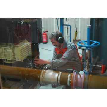 Hibon worker operating a test bench to measure the noise level of a rotary piston blower.
